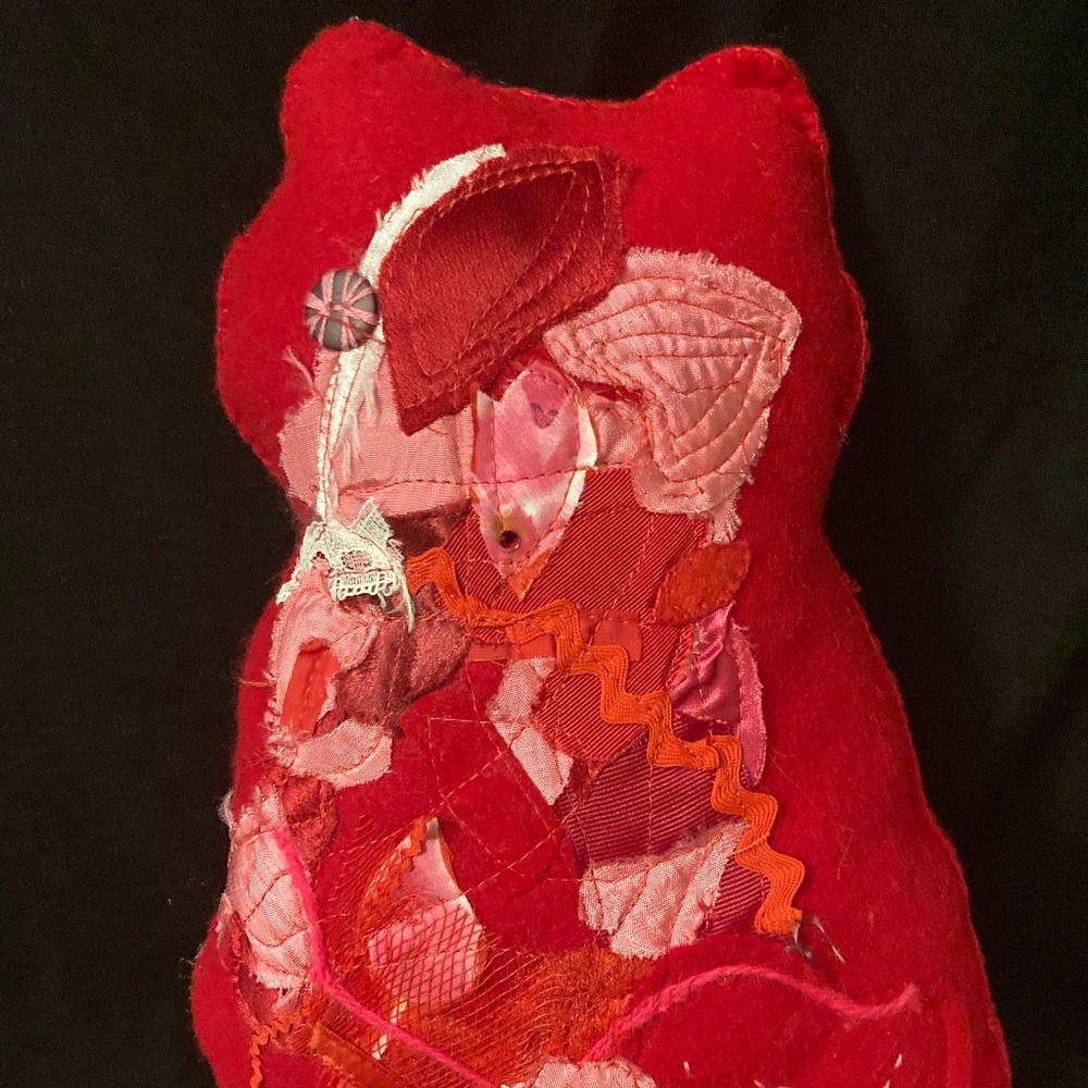 Felted cat pillow with apliqued and stitched designs. Vintage fabric and button.